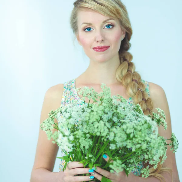 Mladá žena s krásný účes a květiny — Stock fotografie