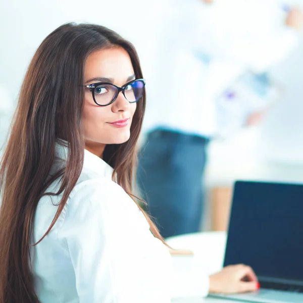 Attraktive Geschäftsfrau sitzt auf Schreibtisch im Büro — Stockfoto