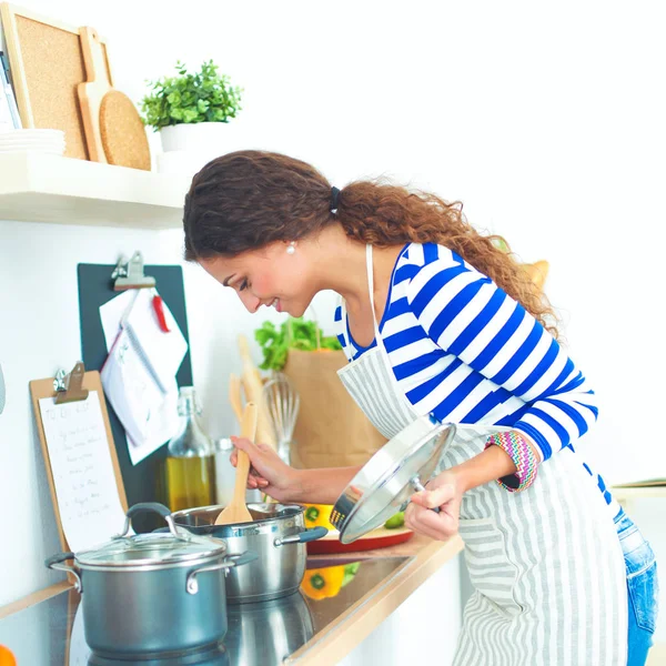 Mooie vrouw staande in keuken met schort — Stockfoto