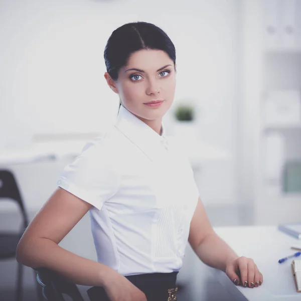 Aantrekkelijke zakenvrouw zit op het bureau in het kantoor — Stockfoto