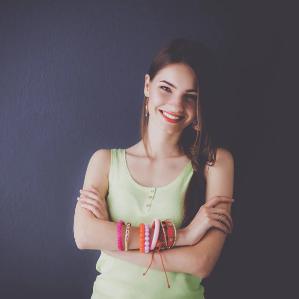 Mujer joven de pie cerca de la pared oscura — Foto de Stock