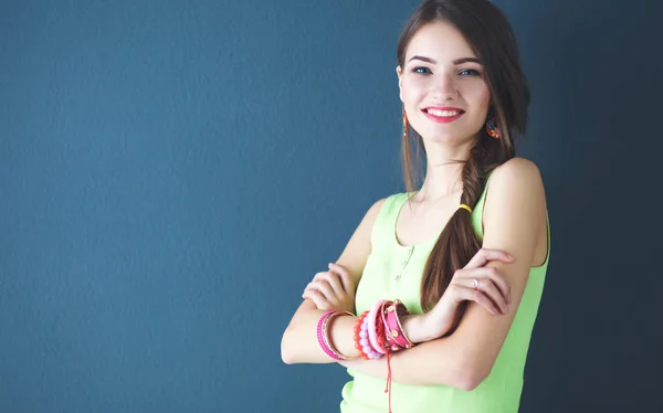 Mujer joven de pie cerca de la pared oscura — Foto de Stock