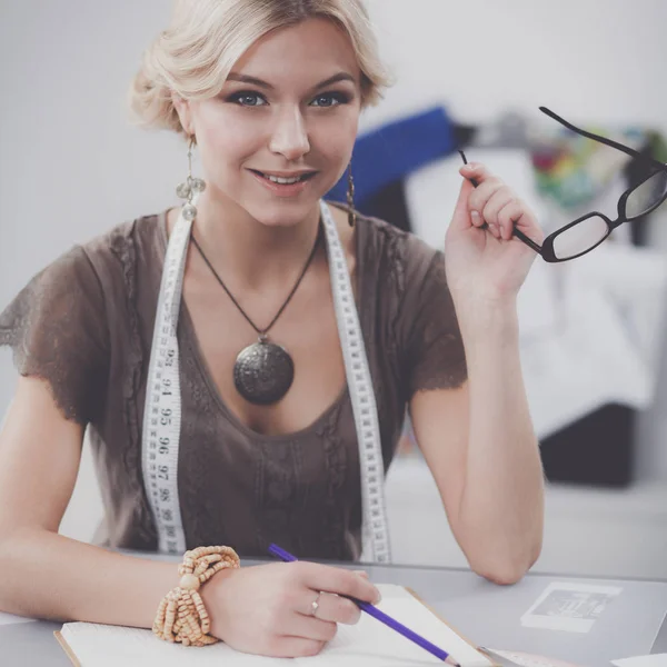 Junge Modedesignerin arbeitet im Atelier. — Stockfoto