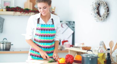 Gülümseyen genç kadın mutfakta salata hazırlık