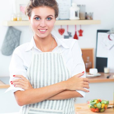 Noel arka plan üzerinde duran mutfakta gülümseyen genç kadın