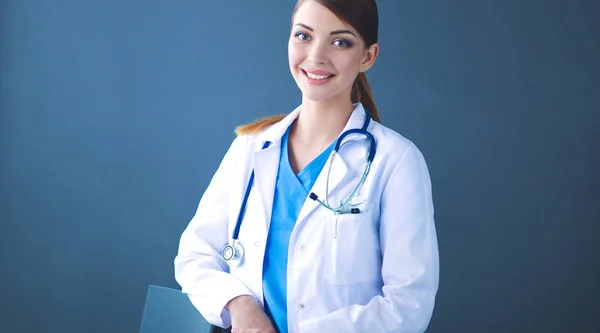 Mooie vrouwelijke arts staan in de buurt van ontlasting geïsoleerde grijze achtergrond — Stockfoto