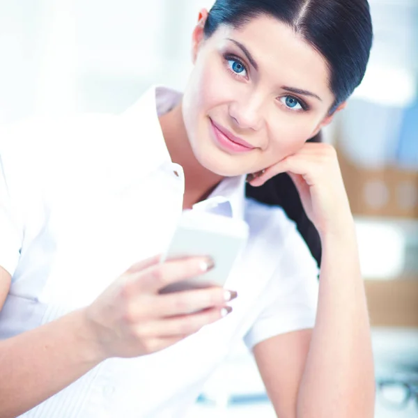 Affärskvinna skicka meddelande med smartphone sitter på kontoret — Stockfoto