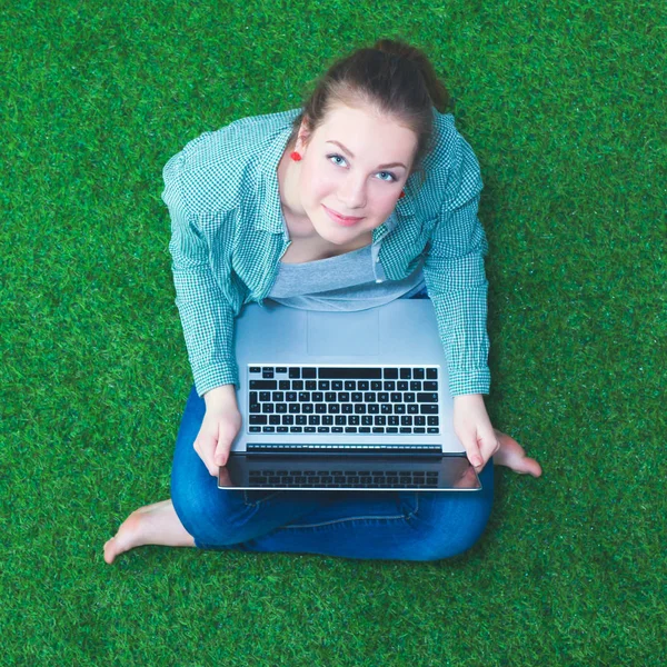 Jonge vrouw op het gras in park of tuin — Stockfoto