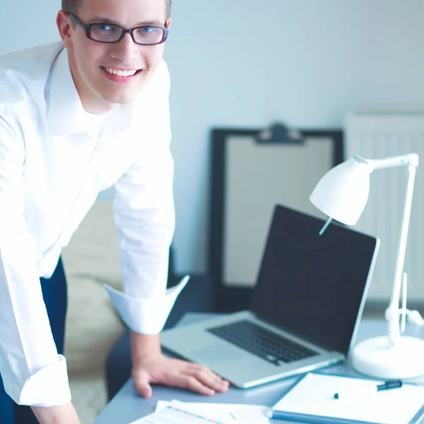 Young businessman working in office, standing near desk — Stock Photo, Image