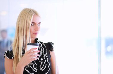 Ofiste bir fincan kahve ayakta tutan işkadını