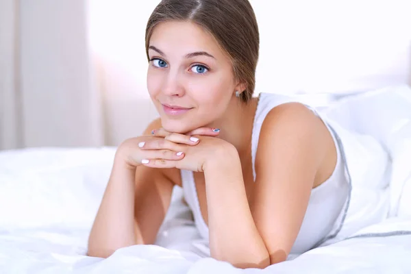 Mooie jonge vrouw liggend in bed comfortabel en gelukzalig — Stockfoto