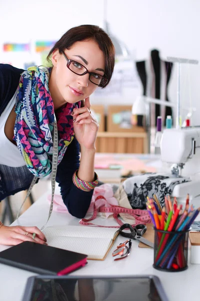 Young dressmaker designing clothes pattern on paper — Stock Photo, Image