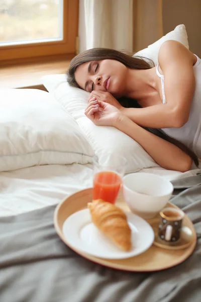 Sarapan di tempat tidur dengan kopi dan croissant untuk wanita muda yang menarik — Stok Foto