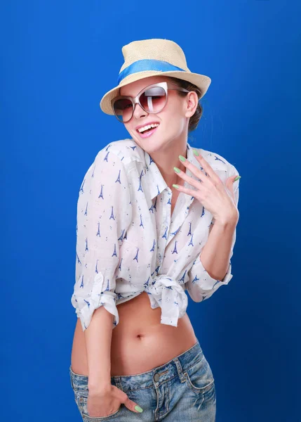 Ritratto di bel modello in cappello con occhiali, isolato su sfondo blu — Foto Stock