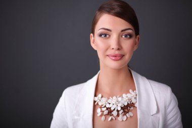 Boncuklar, gri arka plan üzerinde duran genç kadın portresi