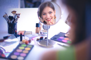 Genç güzel kadın ayna, Masa başında oturan yakınındaki makyaj yapma