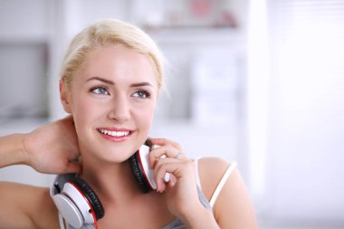 Evdeki genç ve güzel kadın kanepede oturup müzik dinliyor.