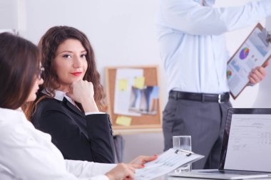 İş adamları iş toplantısında, ofiste oturup tartışıyorlar.