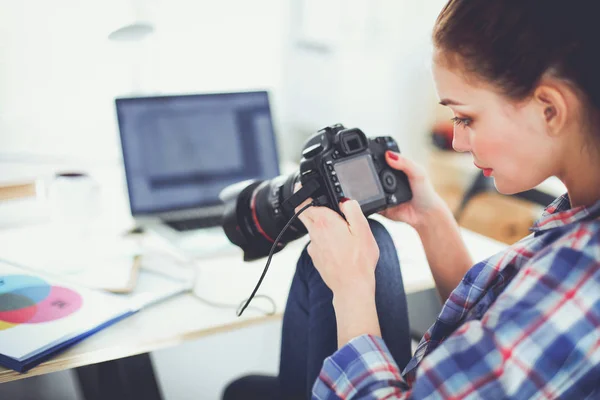 Kobieta fotograf siedzi na biurku z laptopem — Zdjęcie stockowe