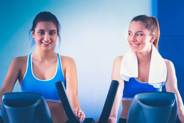 Group of people at the gym exercising on cross trainers