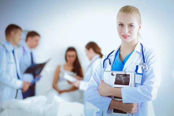 Woman doctor standing with folder at hospital — Stock Photo, Image