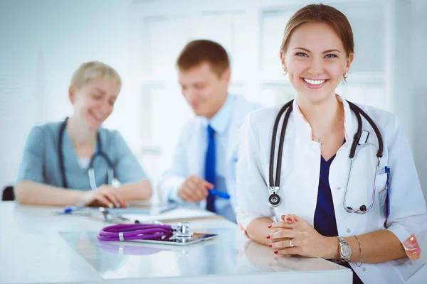 Médica atraente na frente do grupo médico — Fotografia de Stock