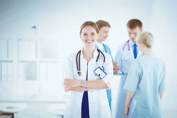 Attractive female doctor in front of medical group — Stock Photo, Image