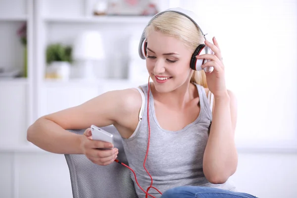 Joven hermosa mujer en casa sentada en el sofá y escuchando música —  Fotos de Stock