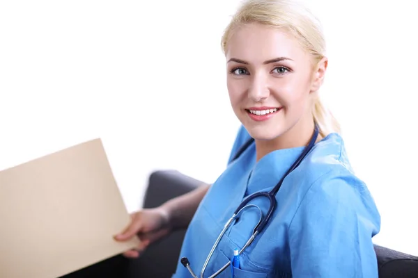 Retrato de un joven médico feliz sentado en el sofá con la carpeta —  Fotos de Stock