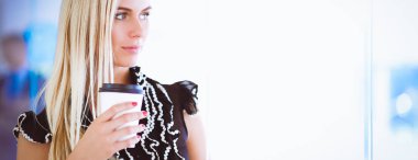 Ofiste bir fincan kahve ayakta tutan işkadını