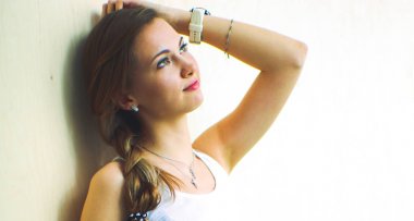 çimenlerin üzerinde kitapla oturan genç kadın