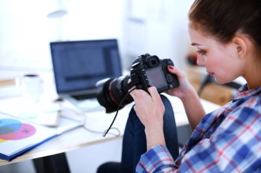 Female photographer sitting on the desk with laptop clipart