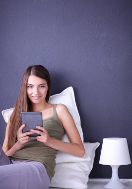 bir yastık ve uçak tablo ile katta oturan güzel esmer kadın