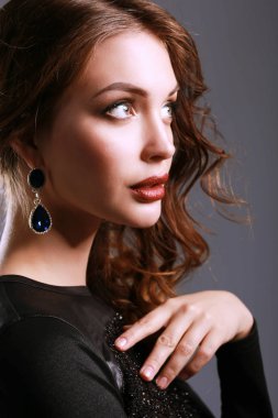 Siyah elbiseli, akşam makyajlı güzel bir kadın.