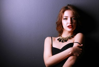 Siyah elbiseli, akşam makyajlı güzel bir kadın.