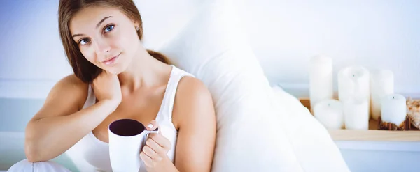 Mulher bonita na cama desfrutando de uma xícara de chá — Fotografia de Stock