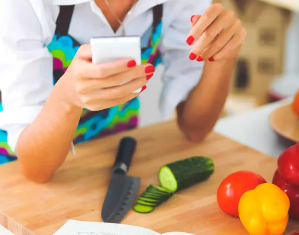 Sorrindo jovem mulher preparando salada na cozinha — Fotografia de Stock