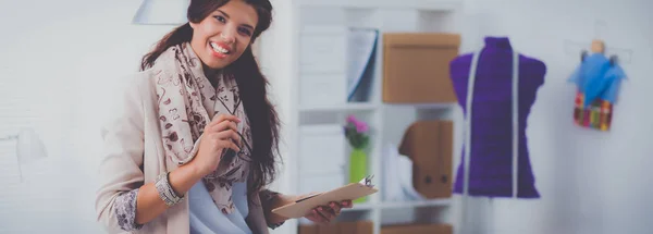 Glimlachende vrouwelijke mode-ontwerper zit aan het bureau — Stockfoto