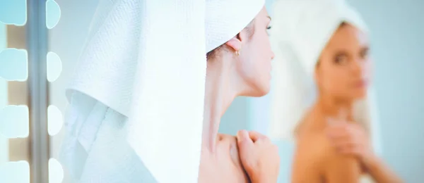 Jeune femme attrayante debout devant le miroir de salle de bain — Photo