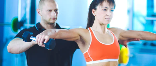 Vacker kvinna på gymmet tränar med hennes tränare — Stockfoto