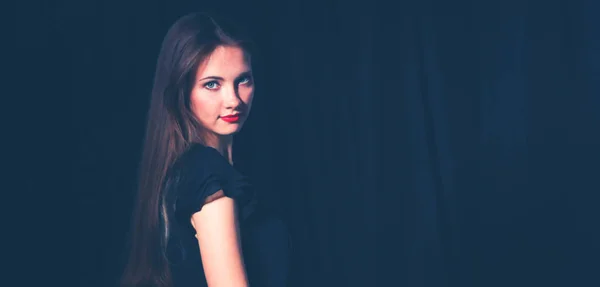 Beautiful woman sitting a chair, isolated on black background — Stock Photo, Image