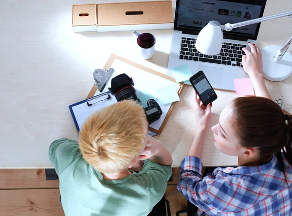 Femme photographe assise sur le bureau avec ordinateur portable — Photo