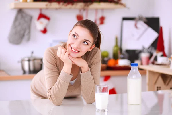 Jovem smilling mulher de pé em sua cozinha — Fotografia de Stock