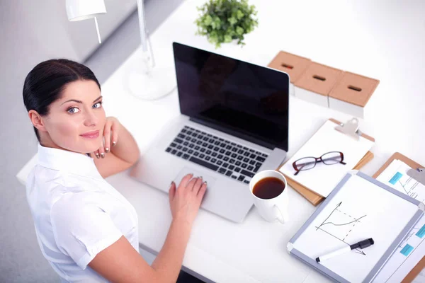 Aantrekkelijke zakenvrouw zit op het bureau in het kantoor — Stockfoto