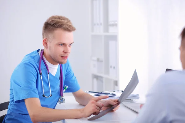 Ritratto di un medico maschio sorridente con computer portatile seduto alla scrivania nello studio medico — Foto Stock