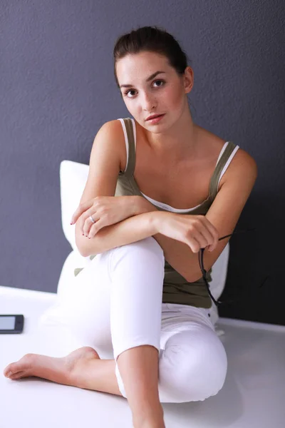 Menina caucasiana atraente sentado no chão com copo e tablet perto da parede — Fotografia de Stock