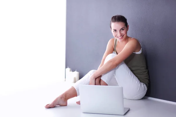 Aantrekkelijke Kaukasische meisje, zittend op de vloer met laptop — Stockfoto