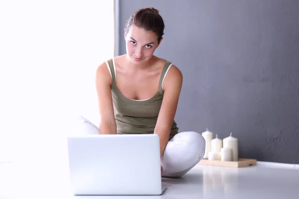 Aantrekkelijke Kaukasische meisje, zittend op de vloer met laptop — Stockfoto