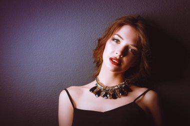 Siyah elbiseli, akşam makyajlı güzel bir kadın.