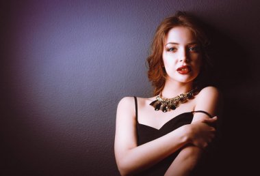 Siyah elbiseli, akşam makyajlı güzel bir kadın.